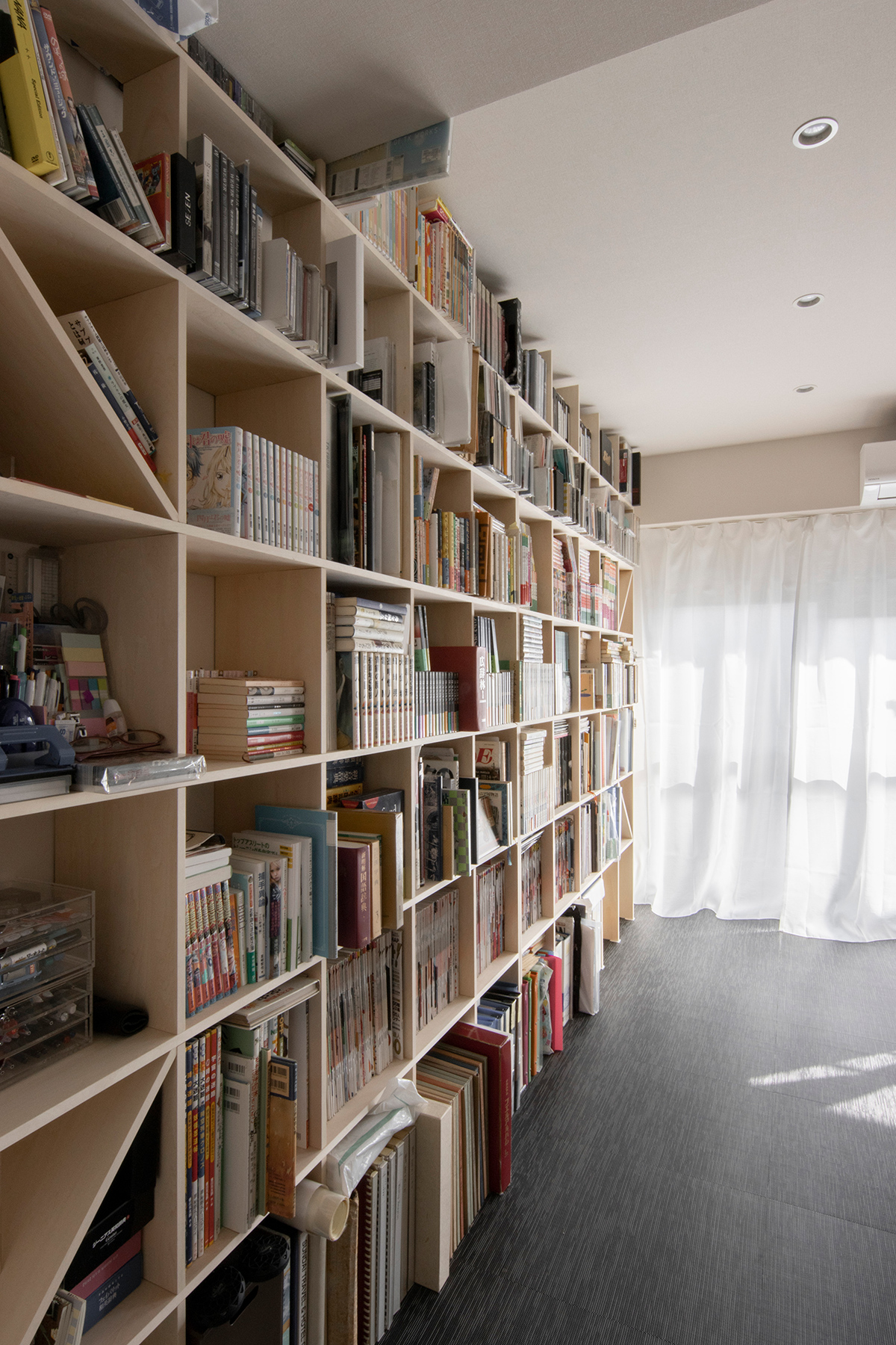 本棚に合わせて生活空間をリフォーム
天井まで壁一面の壁面収納