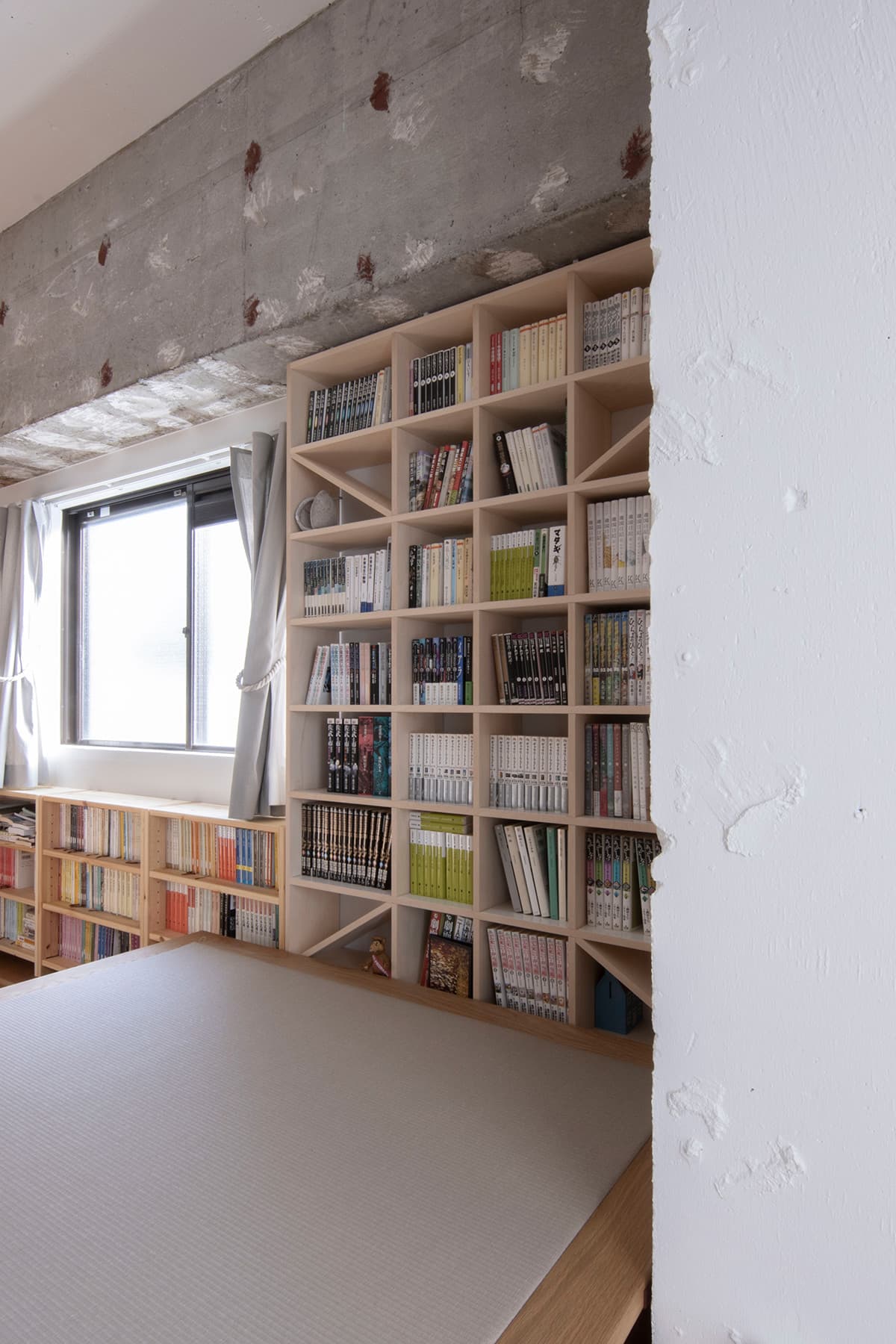 ミニマルにリノべーションされた室内に 壁一面の本棚 Shelf マルゲリータ使用事例