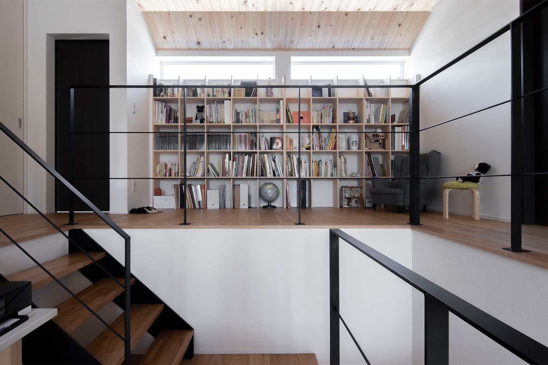 ダイナミックな構成の住宅に壁一面の本棚