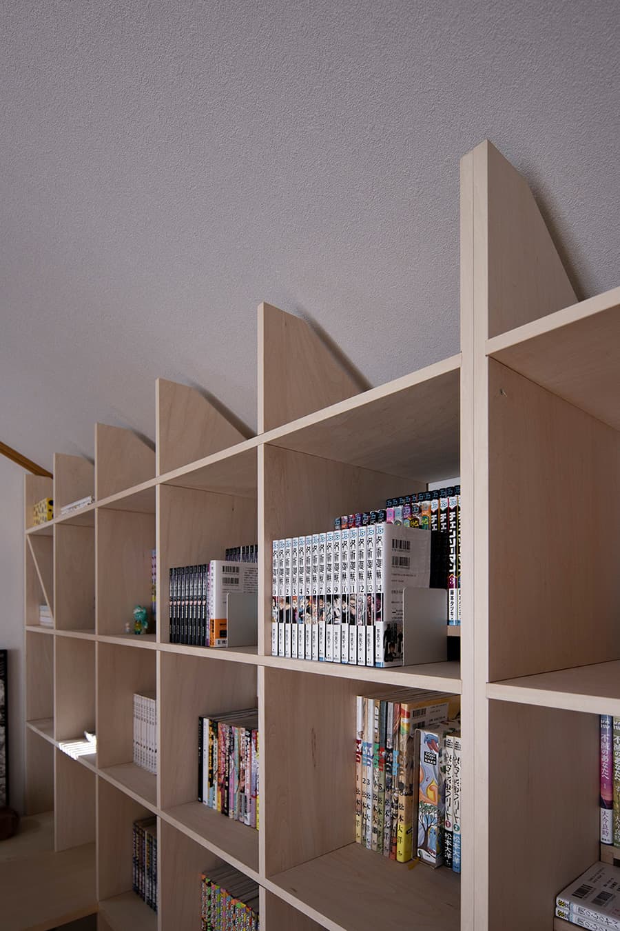 カウンターと本棚を直角に配置したアニメーターの書斎
