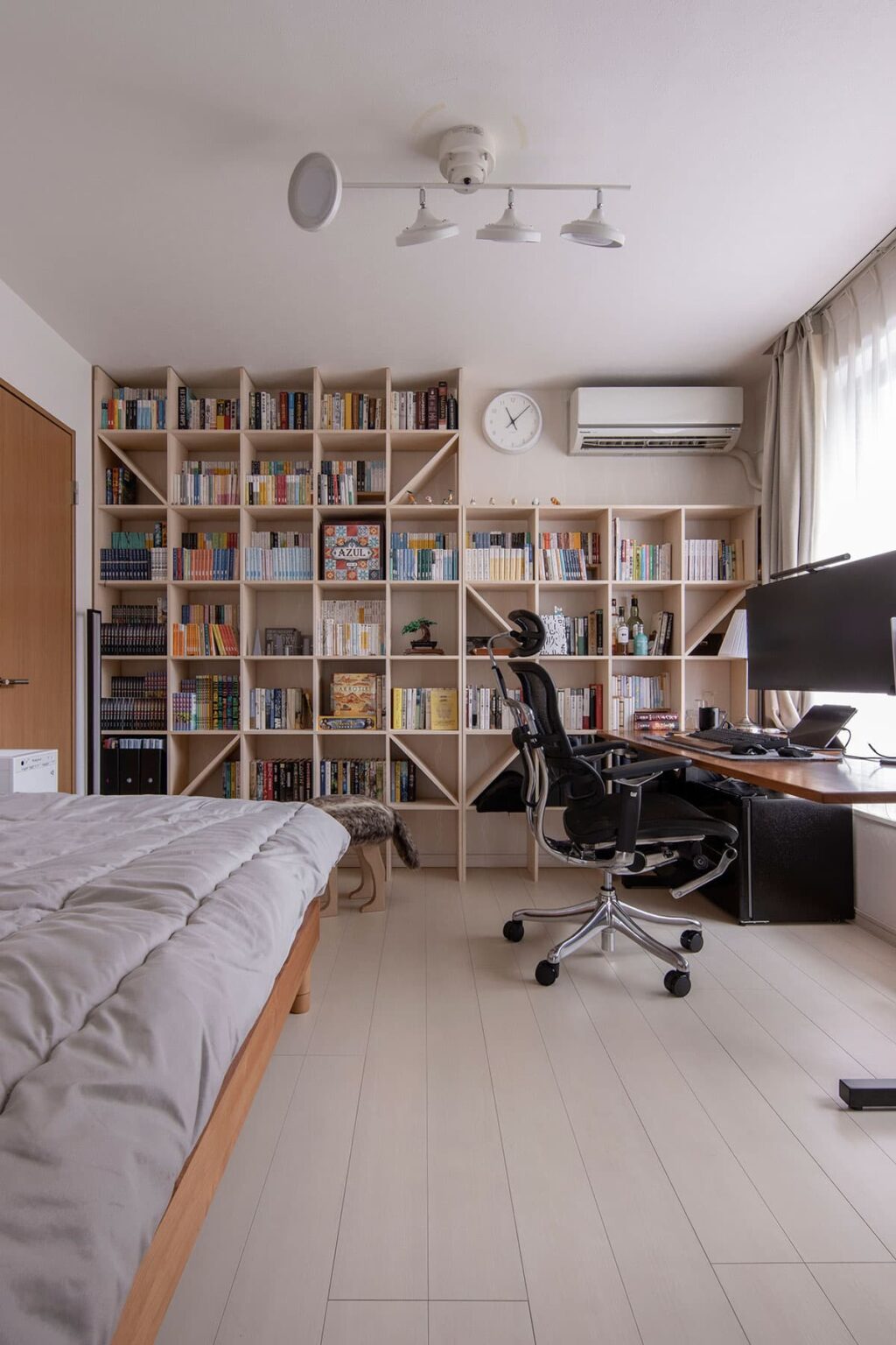 書斎を兼ねたマンションの寝室の壁一面に本棚を設置