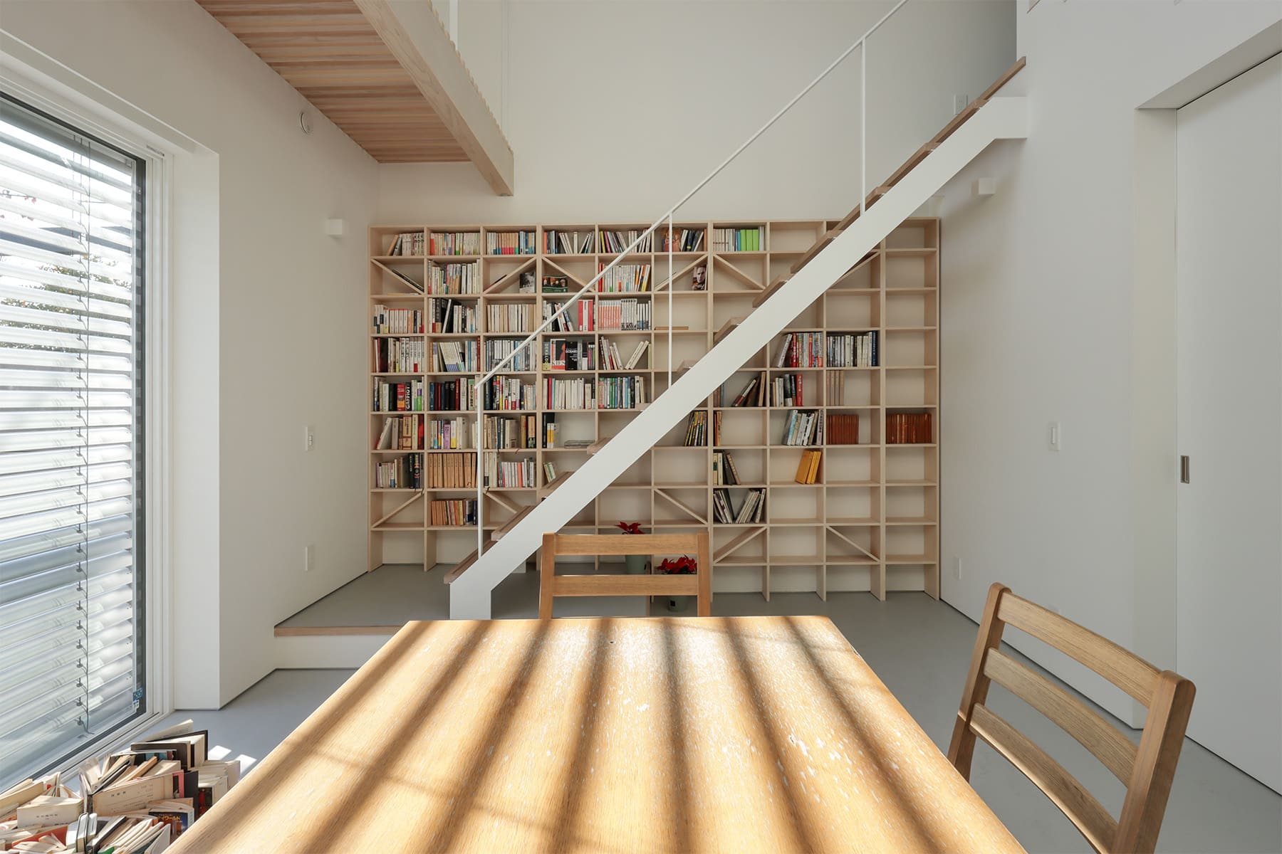 吹き抜けを介して1階および2階に設置された本棚 - Shelf 壁一面のA5本棚 奥行180mm/壁一面の本棚 奥行250mm - マルゲリータお客様事例