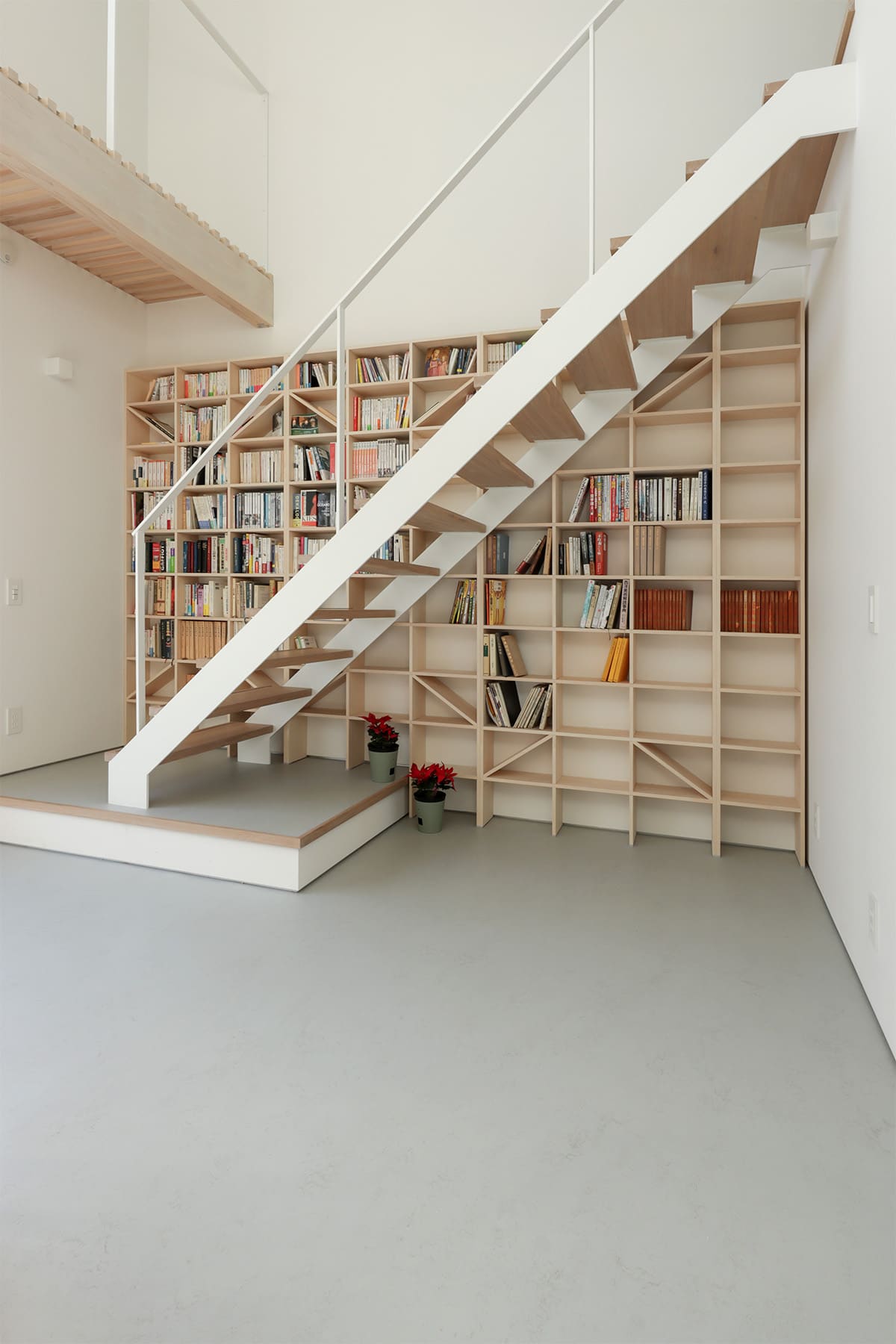 吹き抜けを介して1階および2階に設置された本棚 - Shelf 壁一面のA5本棚 奥行180mm/壁一面の本棚 奥行250mm - マルゲリータお客様事例