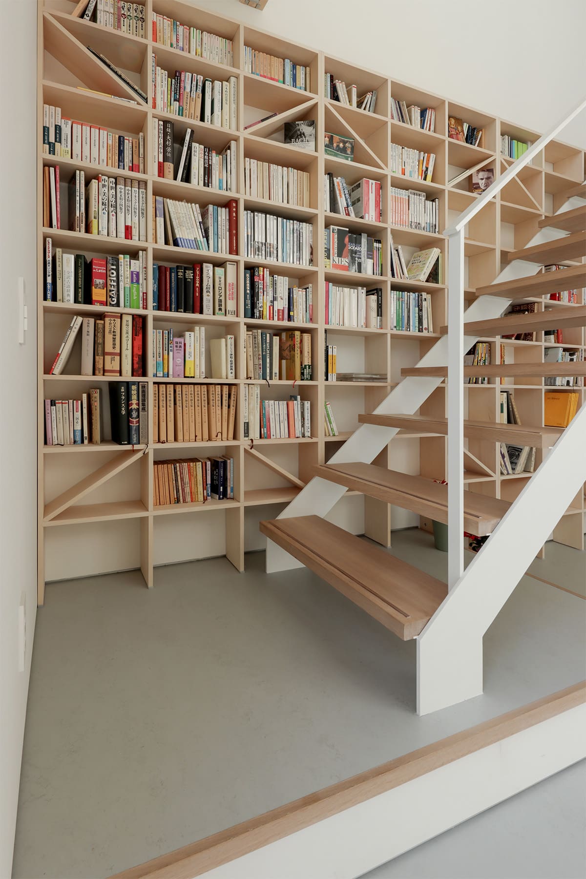 吹き抜けを介して1階および2階に設置された本棚 - Shelf 壁一面のA5本棚 奥行180mm/壁一面の本棚 奥行250mm - マルゲリータお客様事例