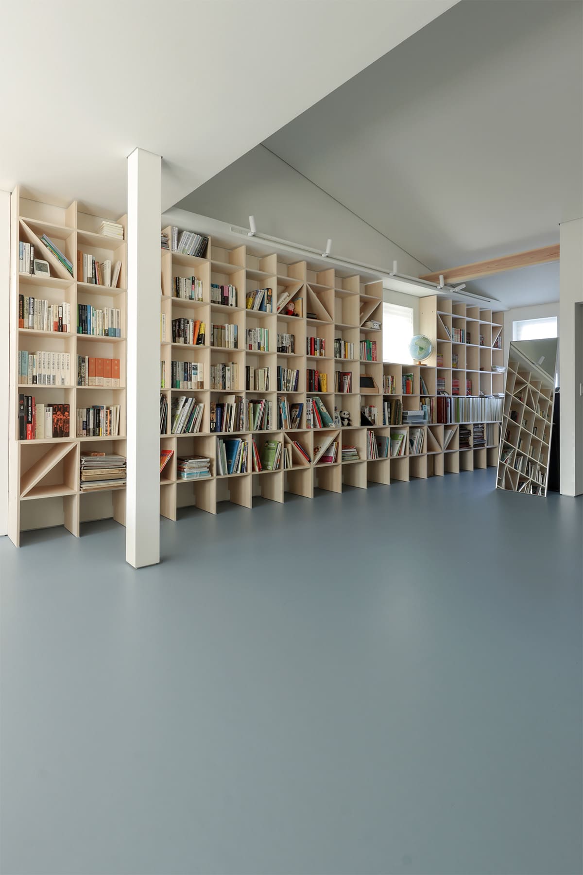 吹き抜けを介して1階および2階に設置された本棚 - Shelf 壁一面のA5本棚 奥行180mm/壁一面の本棚 奥行250mm - マルゲリータお客様事例