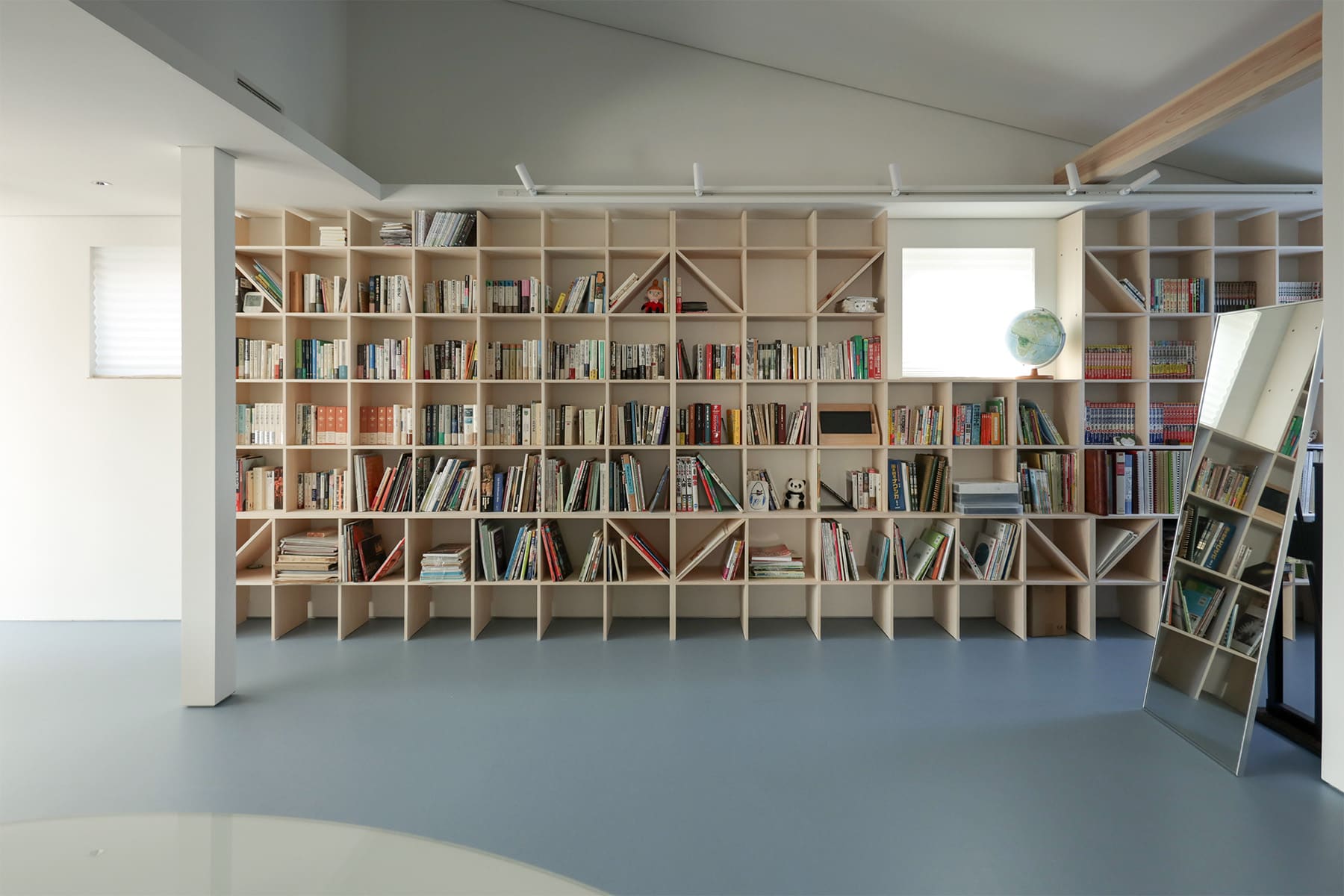 吹き抜けを介して1階および2階に設置された本棚 - Shelf 壁一面のA5本棚 奥行180mm/壁一面の本棚 奥行250mm - マルゲリータお客様事例