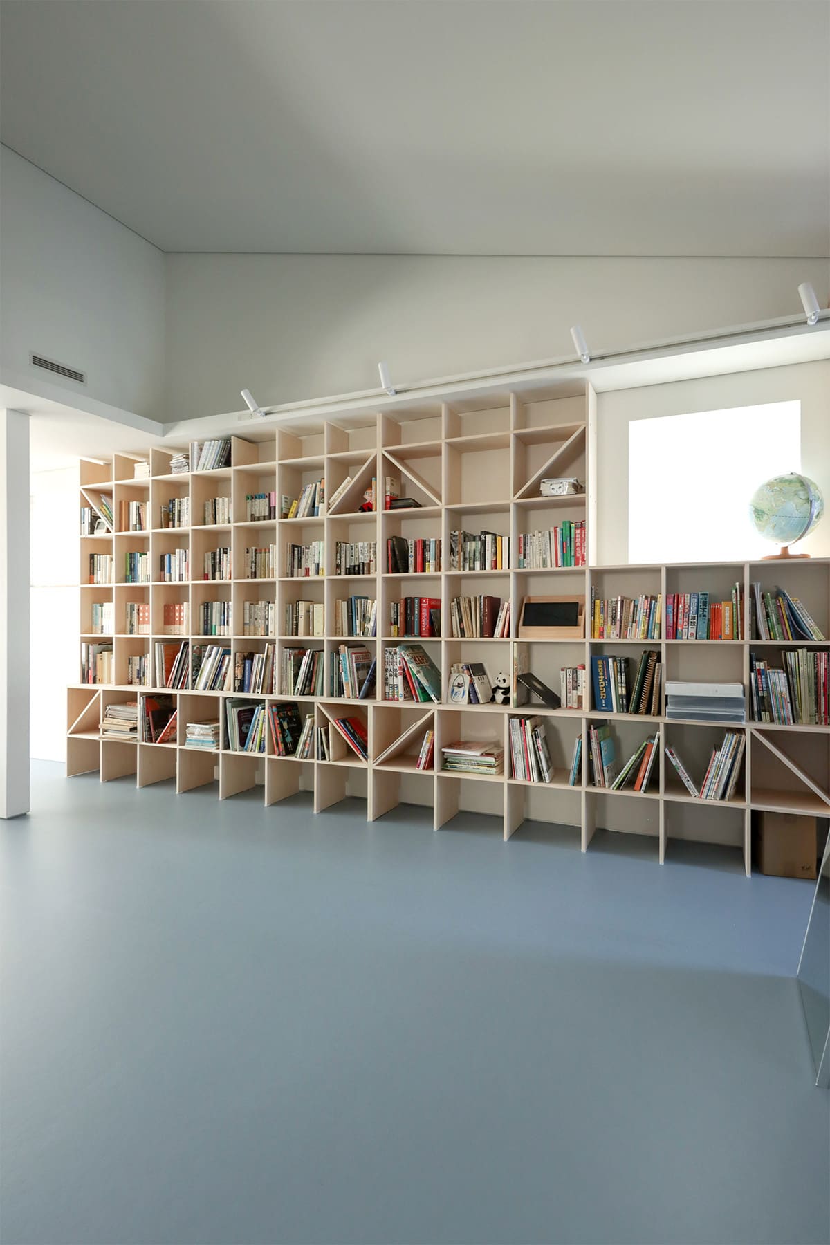 吹き抜けを介して1階および2階に設置された本棚 - Shelf 壁一面のA5本棚 奥行180mm/壁一面の本棚 奥行250mm - マルゲリータお客様事例