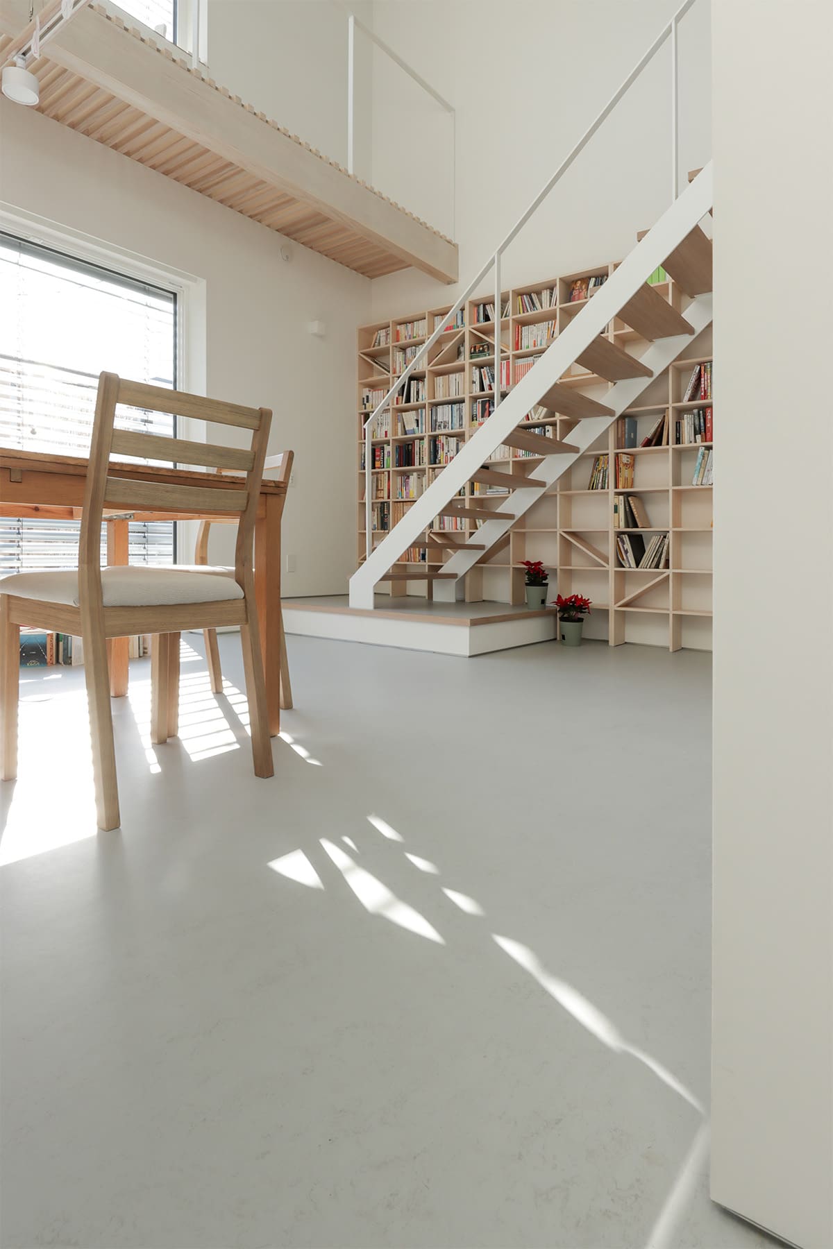 吹き抜けを介して1階および2階に設置された本棚 - Shelf 壁一面のA5本棚 奥行180mm/壁一面の本棚 奥行250mm - マルゲリータお客様事例